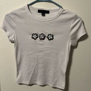 White crop top with brown and blue embroidered flower design.